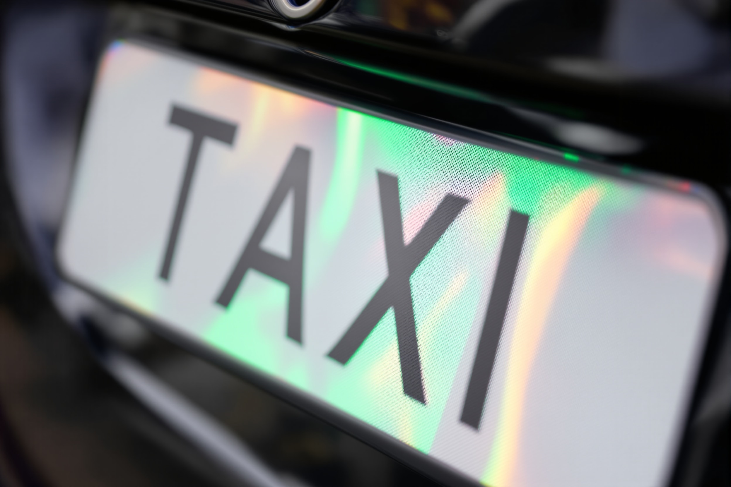 A licensing plate mounted on the rear of a taxi